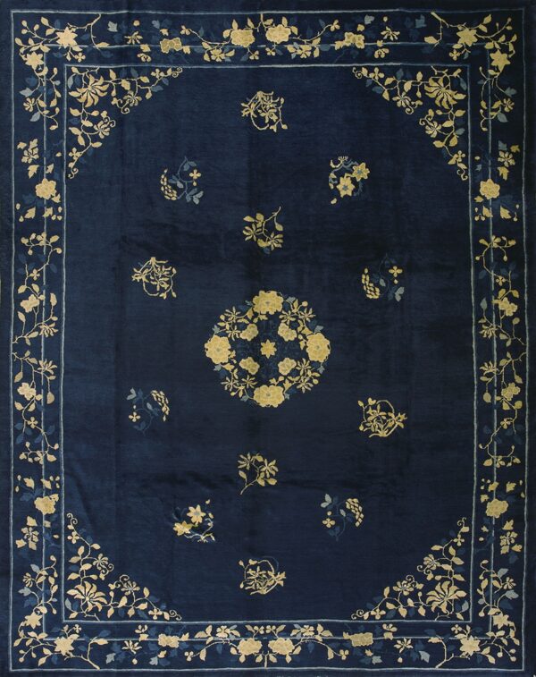 Navy blue rug featuring a low sheen and a floral pattern in gold and light blue throughout the border and field.