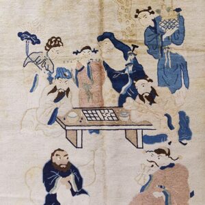 Cream pile rug featuring a figural scene of people gathered around a game table in blue and dusty pink.