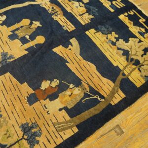 Pictorial rug in deep blue and gold with figures and trees, displayed on honey wood planks.