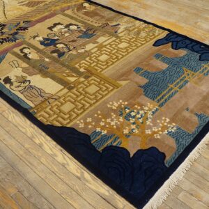 Detailed pictorial rug in beige, navy, and gold, depicting figures and architecture on worn hardwood flooring.