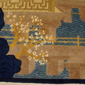 Close-up of a pictorial rug with golden cherry trees, blue water, and brown architecture on wood floors.