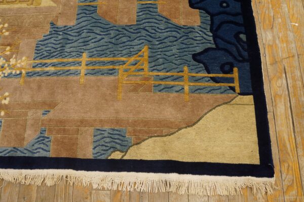 Scenic rug pattern featuring teal water, brown terrain, and golden fence details on a wooden floor.