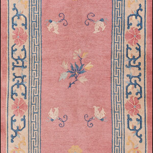 Pink runner rug with scattered blue and yellow blossoms and a wide cream border with blue geometric patterns.