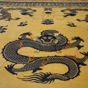 Gold rug featuring large navy blue dragons and clouds, surrounded by a complex geometric border.
