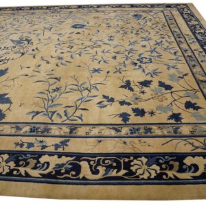 Tan area rug with detailed dark blue floral field patterns and elaborate multiple borders.