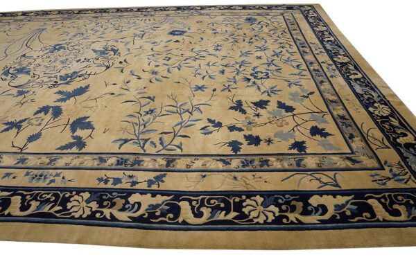 Tan area rug with detailed dark blue floral field patterns and elaborate multiple borders.