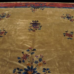 Plush gold rug with scattered blue and maroon floral sprays and a wide red and blue patterned border.