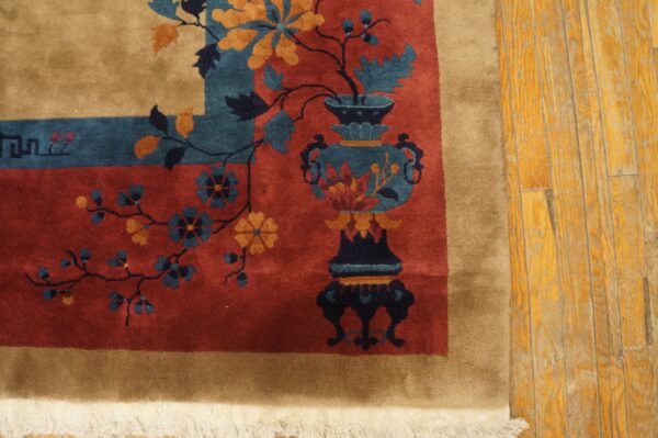High-pile rug in rust, tan, teal, and gold floral patterns rests on worn hardwood flooring.