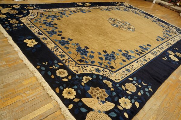 A blue and gold high-pile rug with detailed floral patterns rests on distressed wooden floorboards.