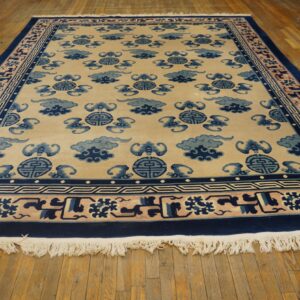 A beige rug with a repeating blue cloud and medallion pattern is displayed on a hardwood floor.