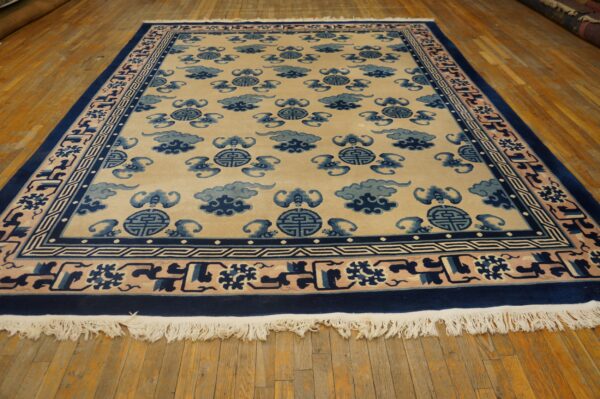 A beige rug with a repeating blue cloud and medallion pattern is displayed on a hardwood floor.