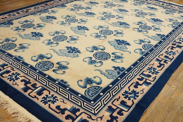 Cream rug with navy and light blue medallion and cloud patterns on hardwood flooring.