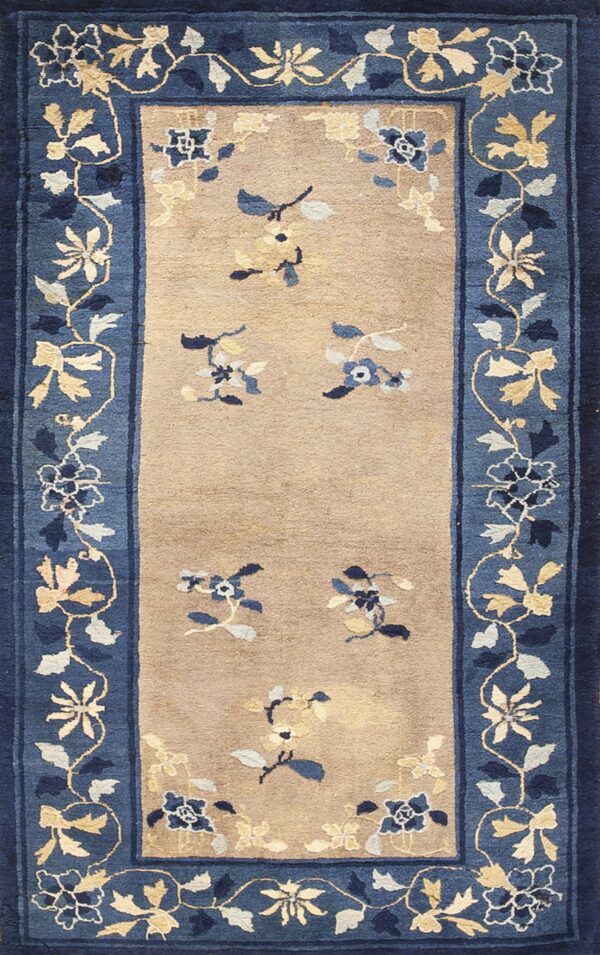 Runner rug with a tan field and detailed blue border showing scattered floral sprigs in blue, cream, and gold.