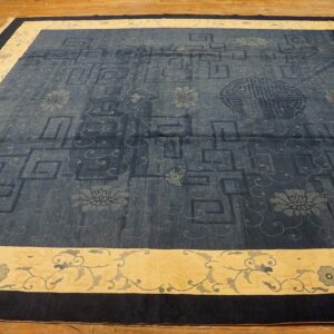 Dark blue patterned rug with tone-on-tone fretwork and florals, framed by a wide cream and dark navy border.