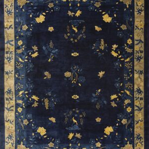 Plush navy rug with a detailed border and central field of gold and blue floral and bird patterns.
