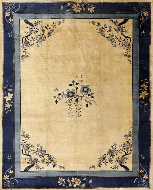 A light gold rug featuring large blue floral corner sprays and wide navy blue striped borders.
