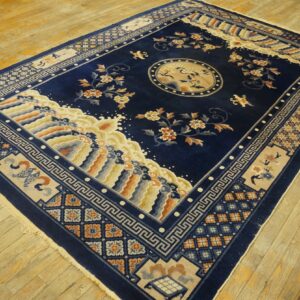 Rectangular navy rug with ornate crane medallion, floral sprays, and colorful waves on wood planks.