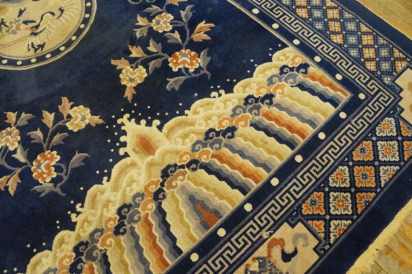Navy rug with dense floral and wave patterns, surrounded by a border with greek key and checkered motifs.