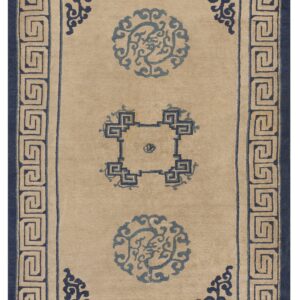 A beige rectangular rug with a navy Greek key border and three blue ornamental central medallions.