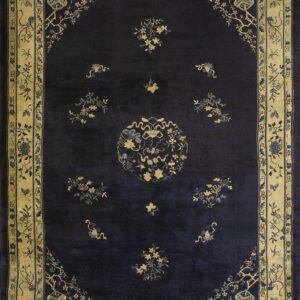 Dark blue rug featuring gold and light blue floral designs, a central medallion, and wide tan borders.