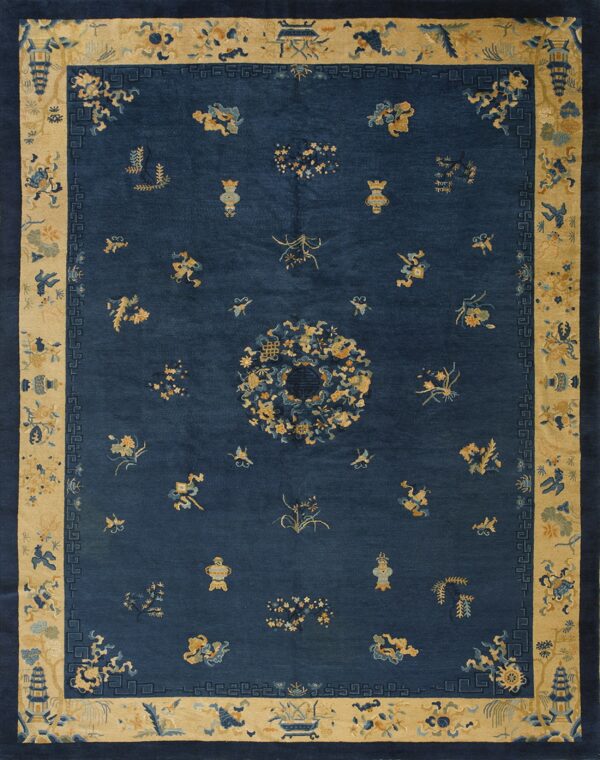A deep blue rug featuring scattered yellow and light blue traditional motifs within a wide patterned beige border.