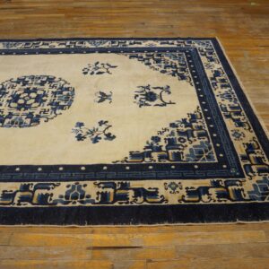 Cream rug with navy blue and yellow geometric patterns rests on rustic wooden flooring.
