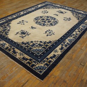 Blue and cream patterned rug with a central medallion lies on distressed wooden plank flooring.
