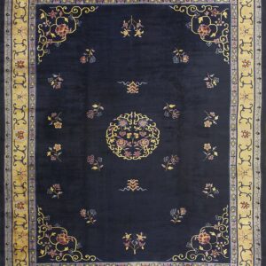 Navy blue rug featuring colorful scattered florals, a central medallion, and wide gold decorative borders.