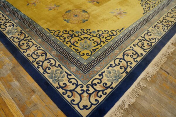 The vibrant gold rug has intricate navy and light blue borders featuring floral and geometric patterns on hardwood floors.