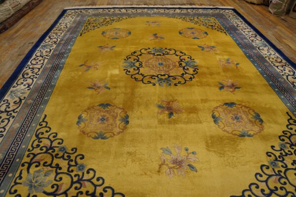 Gold rug with high luster, traditional blue floral medallions, intricate borders, and displayed on worn wood planks.