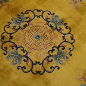 Golden yellow plush rug featuring a central blue floral and geometric medallion design.