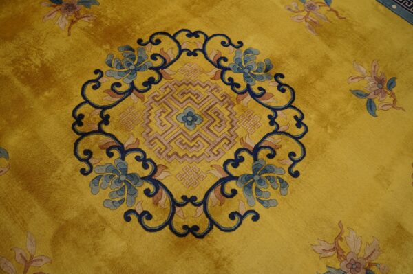 Golden yellow plush rug featuring a central blue floral and geometric medallion design.