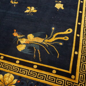 Deep navy rug featuring a gold stylized bird, geometric Greek key border, and large yellow floral motifs.