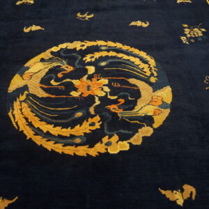 Navy rug detail with an ornate gold and orange medallion and a patterned geometric border.