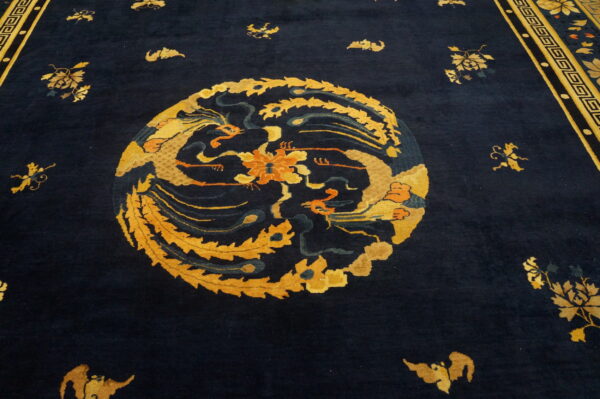 Navy rug detail with an ornate gold and orange medallion and a patterned geometric border.