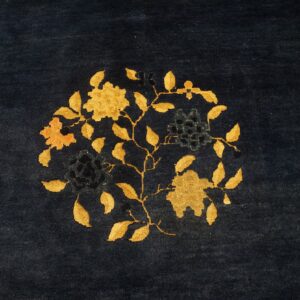 Plush navy rug with a central circular floral motif in golden yellow and deep blue.