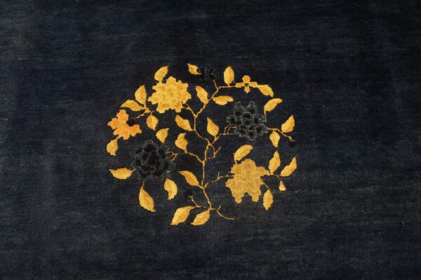 Plush navy rug with a central circular floral motif in golden yellow and deep blue.