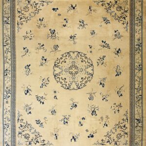 A cream rug with scattered blue floral motifs and a detailed Greek key border surrounding a central medallion.