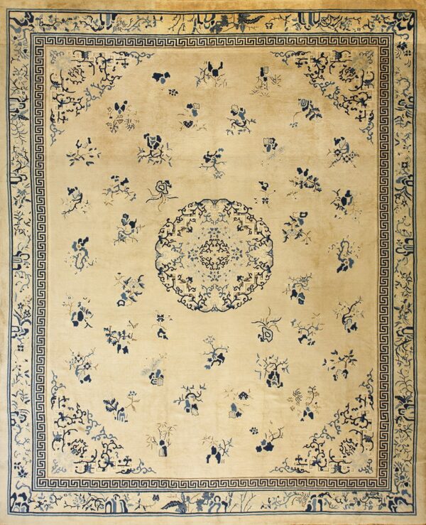 A cream rug with scattered blue floral motifs and a detailed greek key border surrounding a central medallion.