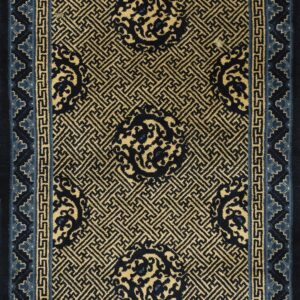 Gold and navy rug featuring detailed geometric fretwork, scrolling medallions, and a light blue stepped border.