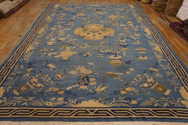 Blue rug featuring yellow and navy botanical, vase, and medallion patterns on wood floors.