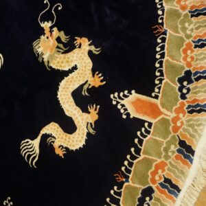 Navy rug with a cream and orange dragon motif surrounded by a multicolored geometric and cloud border.