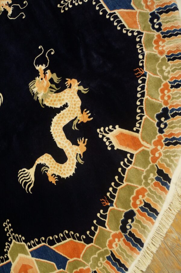 Navy rug with a cream and orange dragon motif surrounded by a multicolored geometric and cloud border.