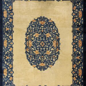 Yellow rug featuring a central oval of intricate blue and orange floral scrollwork and a wide navy border.