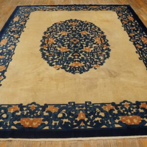 Cream rug featuring a bold navy blue and rust ornate medallion and thick border on wood floor.