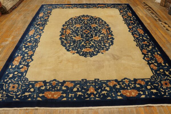 Cream rug featuring a bold navy blue and rust ornate medallion and thick border on wood floor.