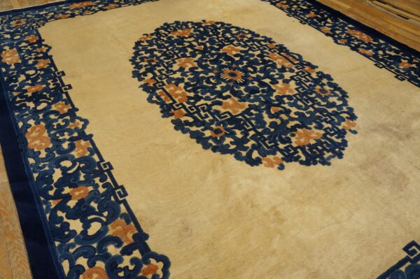 Plush beige rug featuring a large navy and terracotta floral medallion and border on wood flooring.