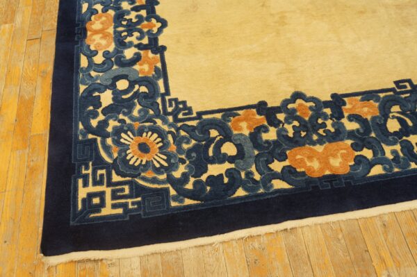 Yellow rug with high-contrast navy, blue, and orange floral scroll border on wood floors.