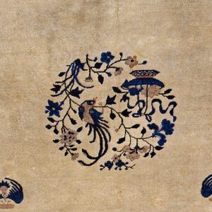 A textured beige rug features a central blue bird and flower medallion with smaller blue corner accents.