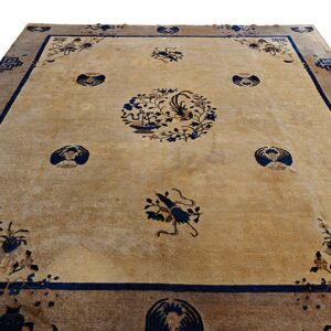 Tan rug with navy blue floral and bird motifs, surrounded by a wide brown outer border.